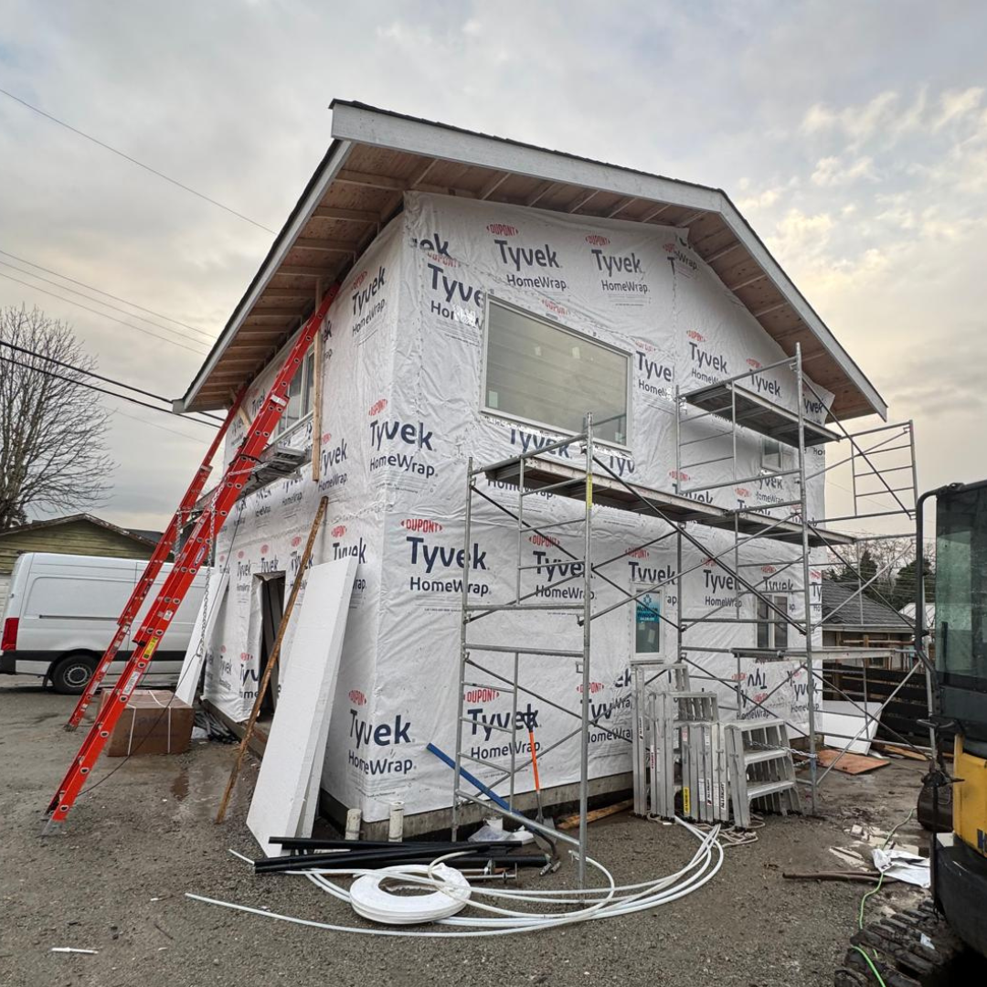 Residential home under construction in Vancouver with scaffolding and Tyvek wrap